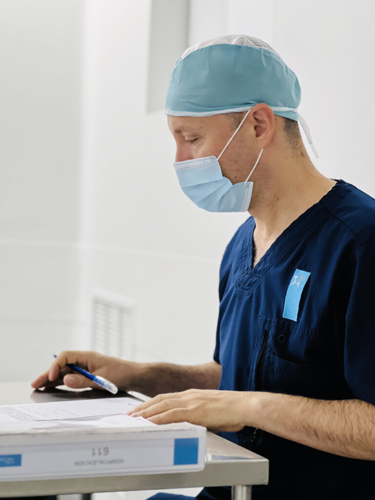 Médico con uniforme y gorro azul.